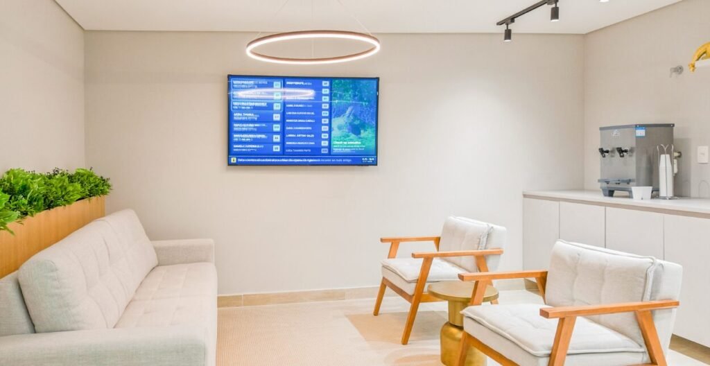 Sala de espera da BR MED com sofá, poltronas e painel de chamada