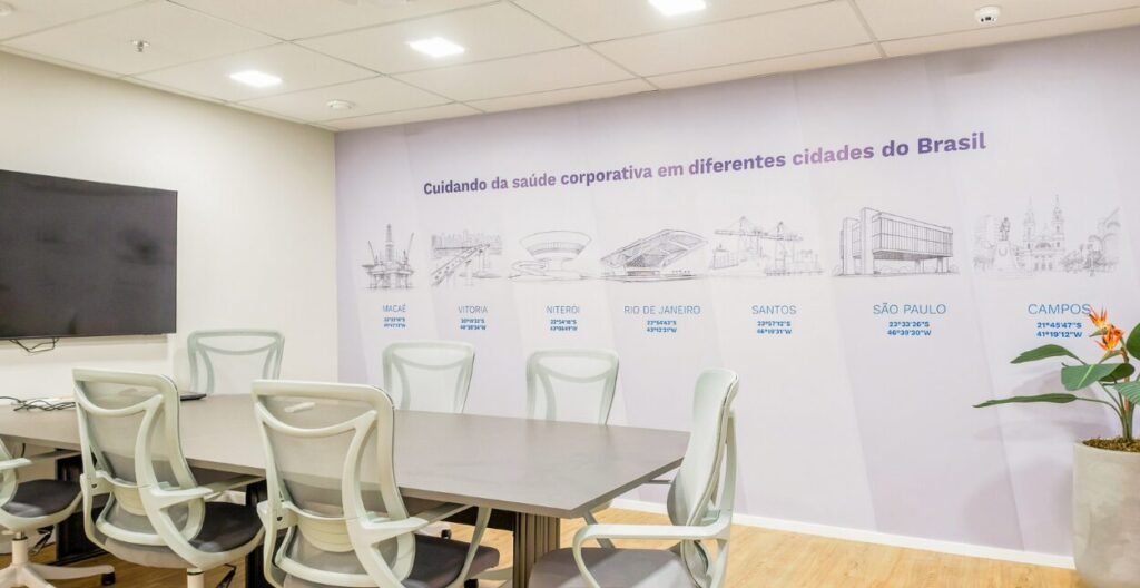 Sala de reunião da BR MED com mesa oval e mural sobre a atuação da empresa no Brasil