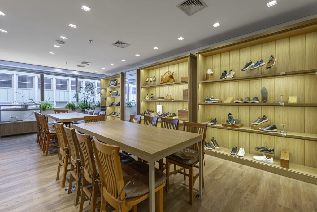 Showroom da MR.CAT com prateleiras iluminadas e mesa de reunião de madeira