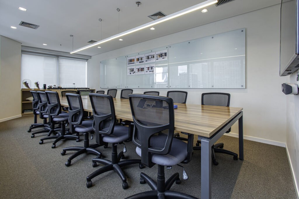 Sala de reunião da MR.CAT com mesa longa e quadro branco