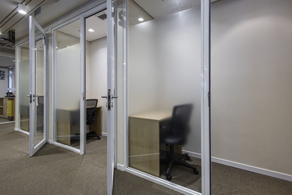 Corredor da MR.CAT com divisórias e portas de vidro