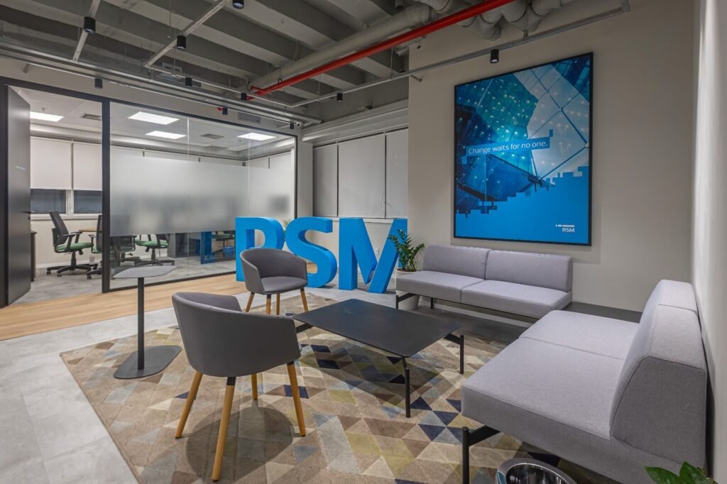 Lounge da RSM com letreiro tridimensional da marca e poltronas