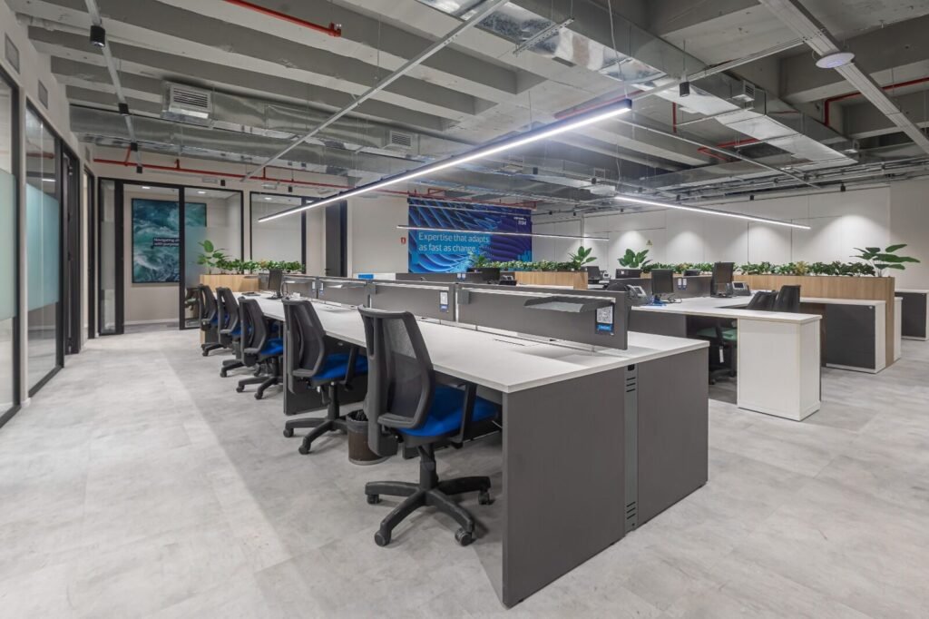 Open office da RSM com estações de trabalho e salas de reunião ao fundo