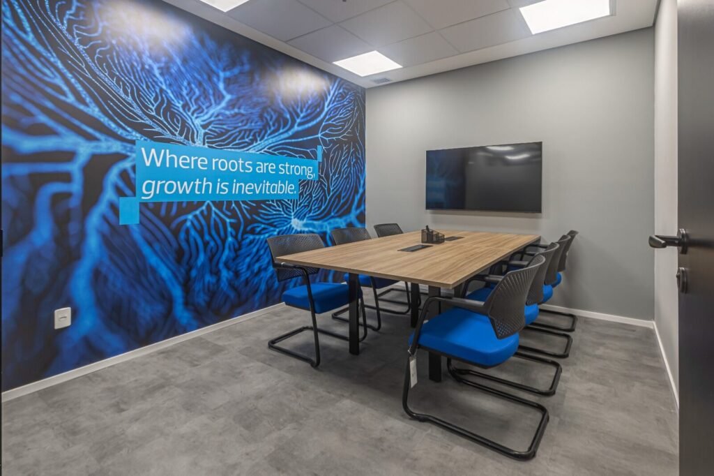 Sala de reunião da RSM com mural azul e mesa de madeira