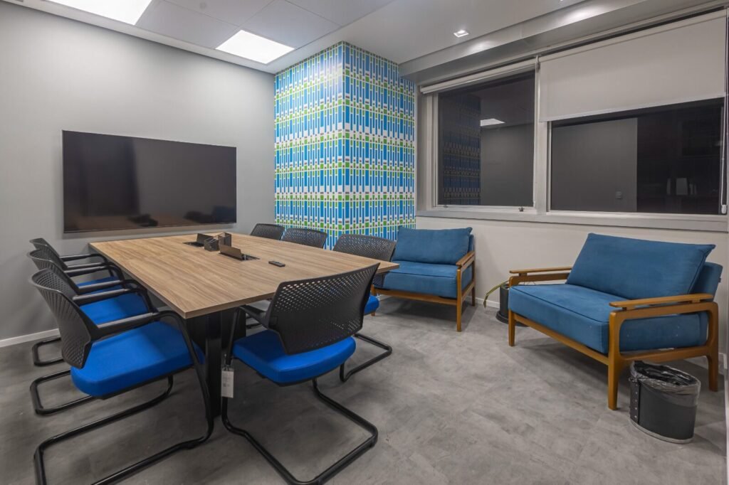 Sala de reunião da RSM com cadeiras azuis, sofá e painel texturizado