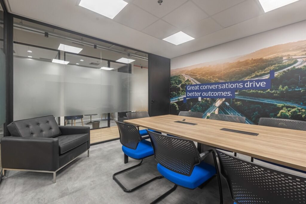 Sala de reunião da RSM com mural de paisagem e mesa longa