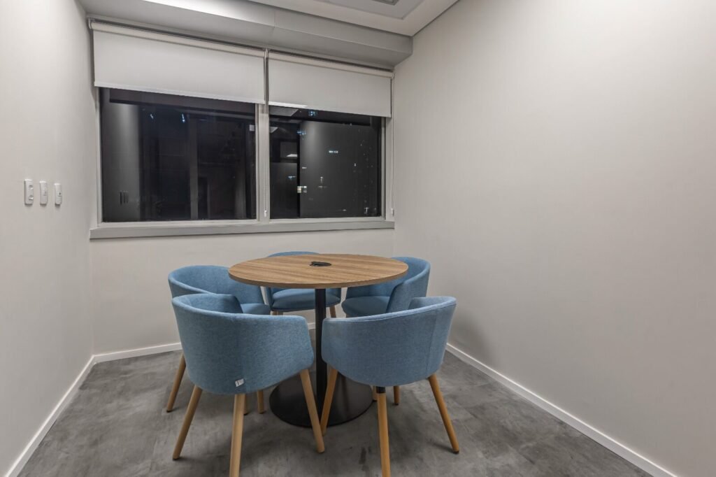 Sala de reunião informal da RSM com mesa redonda e poltronas azuis