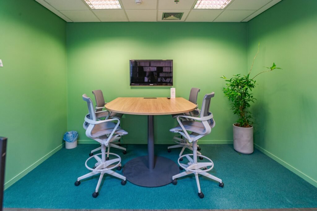 Sala de reunião pequena pintada de verde no escritório da ERM