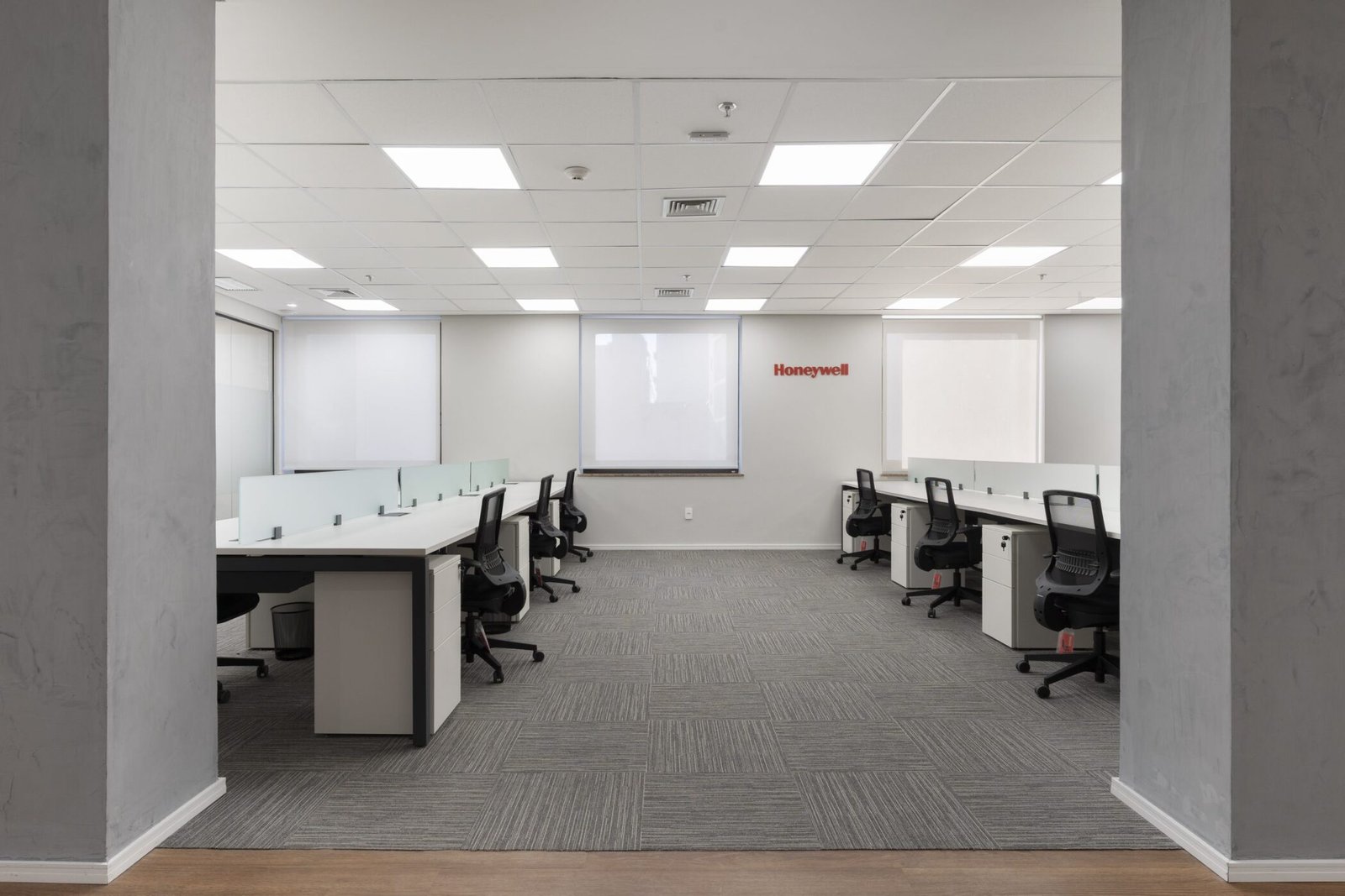 Salão de trabalho da Honeywell com carpete e pilares aparentes
