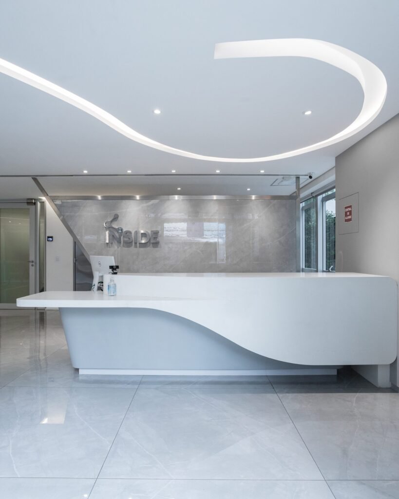 Balcão branco de linhas orgânicas na recepção da Inside Diagnósticos