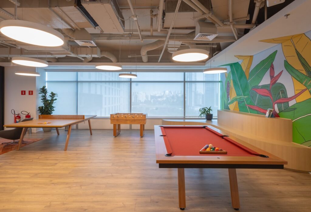 Sala de jogos com mesa de sinuca e mural no escritório da Takeda